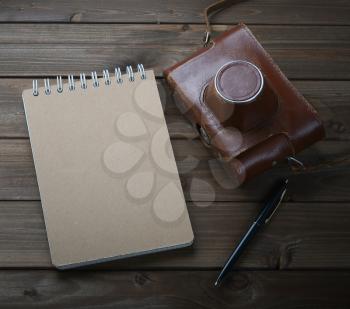 Blank notebook with fountain pen and retro camera on wooden table