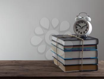 alarm clock stand on a pile of books