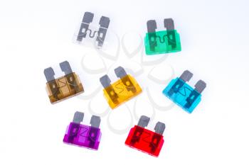 Different colors of  car fuses with a white background