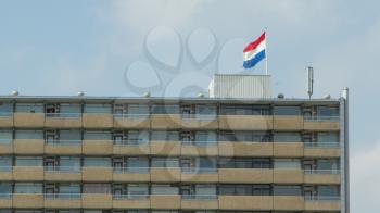 LEEUWARDEN,FRIESLAND,HOLLAND-APRIL 30: Dutch flag on top of a block of flats against the blue sky on Queen's Day on April 30, 2012 at Leeuwarden,Friesland,Holland