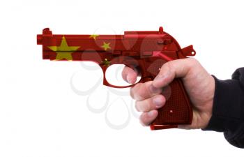 Pistol with chinese flag pattern in hand, isolated on white background