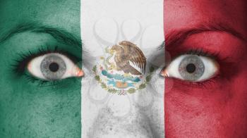 Close up of eyes. Painted face with flag of Mexico