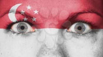 Close up of eyes. Painted face with flag of Singapore