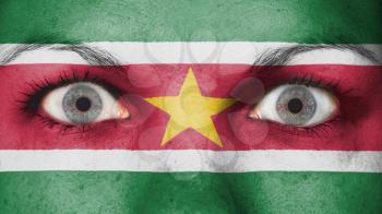 Close up of eyes. Painted face with flag of Suriname
