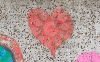 Red heart graffiti over grunge cement wall