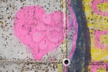 Pink heart graffiti over grunge cement wall