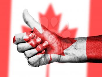Canadian flag on thumbs up hand isolated on a flag background