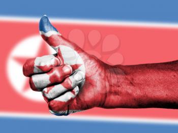 North Korean flag on thumbs up hand isolated on a flag background