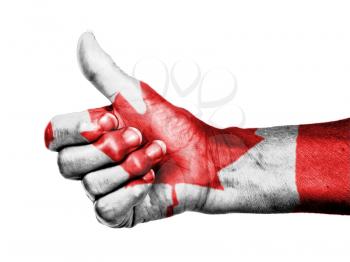Old woman with arthritis giving the thumbs up sign, wrapped in flag pattern, Canada