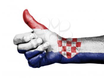 Old woman with arthritis giving the thumbs up sign, wrapped in flag pattern, Croatia