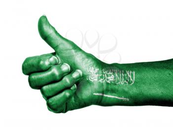 Old woman with arthritis giving the thumbs up sign, wrapped in flag pattern, Saudi Arabia