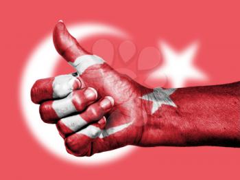 Turkey flag on thumbs up hand isolated on a flag background