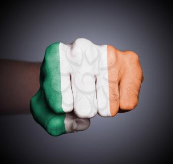 Front view of punching fist on gray background, flag of Ireland