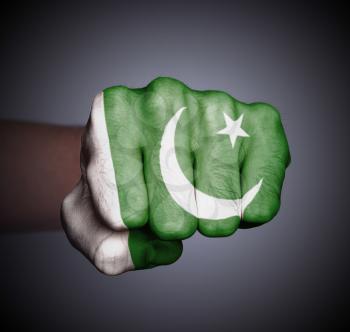 Front view of punching fist on gray background, flag of Pakistan