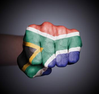 Front view of punching fist on gray background, flag of South Africa