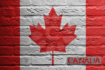 Brick wall with a painting of a flag isolated, Canada