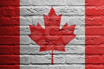 Brick wall with a painting of a flag isolated, Canada