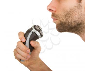 Young man shaving his beard off with an electric shaver