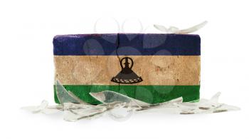 Brick with broken glass, violence concept, flag of Lesotho