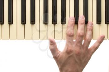 Piano keyboard with hand on white background