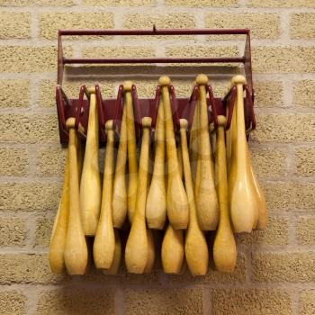 Gymnastic wooden clubs in a rack on the wall