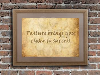 Old wooden frame with written text on an old wall - Failure brings you closer to success