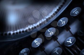 Close up photo of antique typewriter keys, shallow focus, cold blue