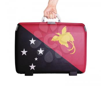 Used plastic suitcase with stains and scratches, printed with flag, Papua New Guinea