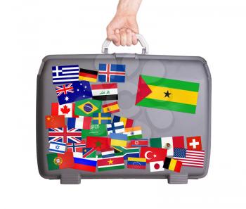 Used plastic suitcase with lots of small stickers, large sticker of Sao Tome and Principe