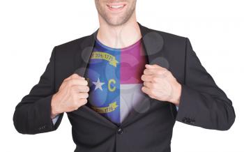 Businessman opening suit to reveal shirt with state flag (USA), North Carolina
