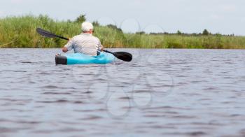 Man paddling in a blue kayak in the Netherlands