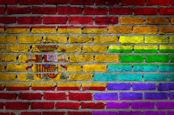 Dark brick wall texture - coutry flag and rainbow flag painted on wall - Spain