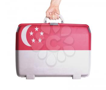 Used plastic suitcase with stains and scratches, printed with flag, Singapore