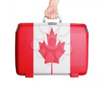Used plastic suitcase with stains and scratches, printed with flag, Canada
