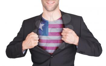 Businessman opening suit to reveal shirt with flag, Liberia