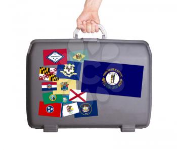 Used plastic suitcase with stains and scratches, stickers of US States, Kentucky