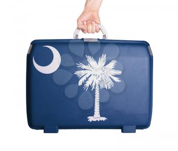 Used plastic suitcase with stains and scratches, printed with flag, South Carolina