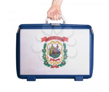 Used plastic suitcase with stains and scratches, printed with flag, West Virginia