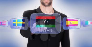 Hand pushing on a touch screen interface, choosing language or country, Libya
