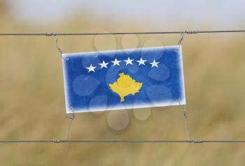 Border fence - Old plastic sign with a flag - Kosovo