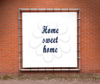 Large banner with inspirational quote on a brick wall - Home sweet home