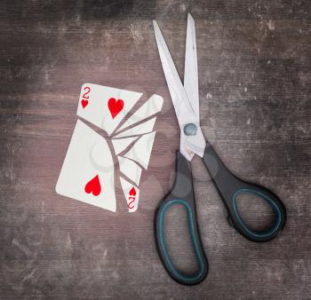 Concept of addiction, card with scissors, two of hearts
