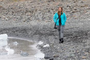 Woman walking over the beach at Jokulsarlon glacier lagoon in southern Iceland
