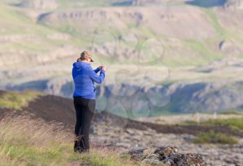 Shot of a young woman looking at the landscape while hiking in Iceland
