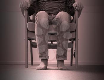 Man sitting in armchair, slightly creepy setting