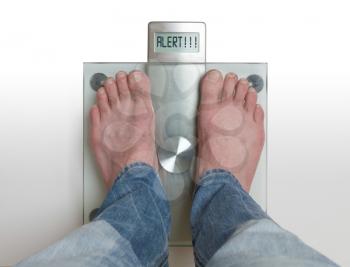 Closeup of man's feet on weight scale - Alert