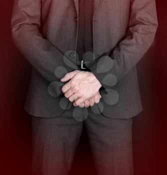 Businessman standing with hands folded - Grey suit