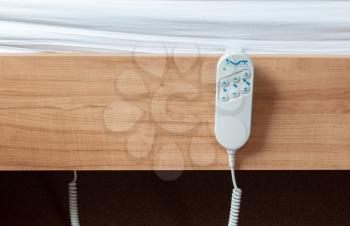 Bed remote hanging at the side from a bed, luxury item