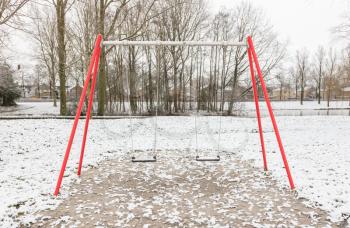 Empty swing in playground - Covered in snow