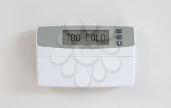 Vintage digital thermostat hanging on a white wall - Covert in dust - Too cold